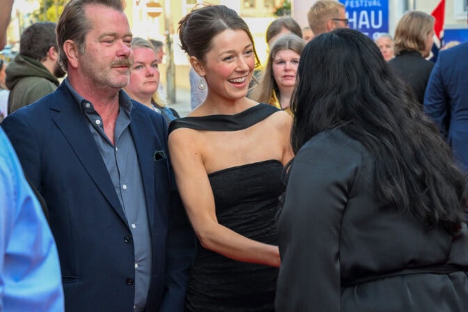 Fridtjov Såheim og Andrea Berntzen hilser på kultur- og likestillingsminister Lubna Jaffery på den røde løperen under Den norske filmfestivalen 2025 i forkant av premierevisningen av åpningsfilmen «Blücher». Foto: John Berge. © 